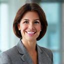 A confident-looking financial advisor smiling in a bright office environment.